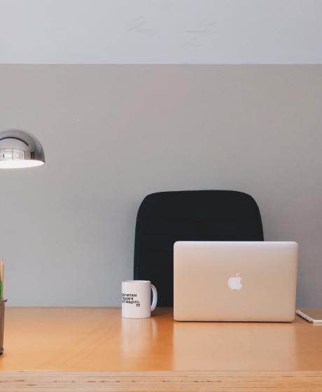 Schreibtisch mit Lampe und Laptop