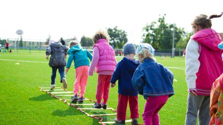 die Rückseite von Kinder, die auf einem Spielplatz spielen